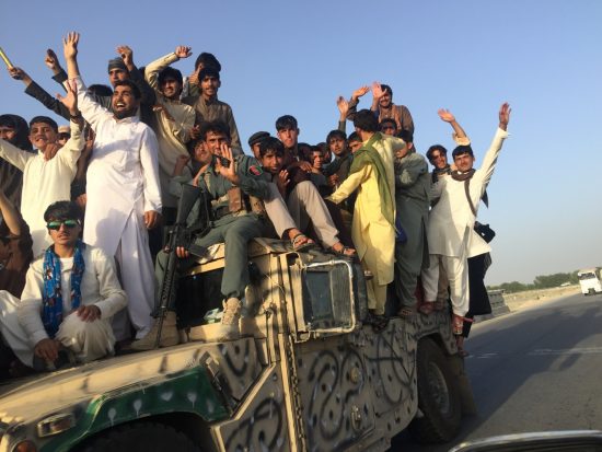 軍の車両に乗って停戦の喜びを表す若者たち