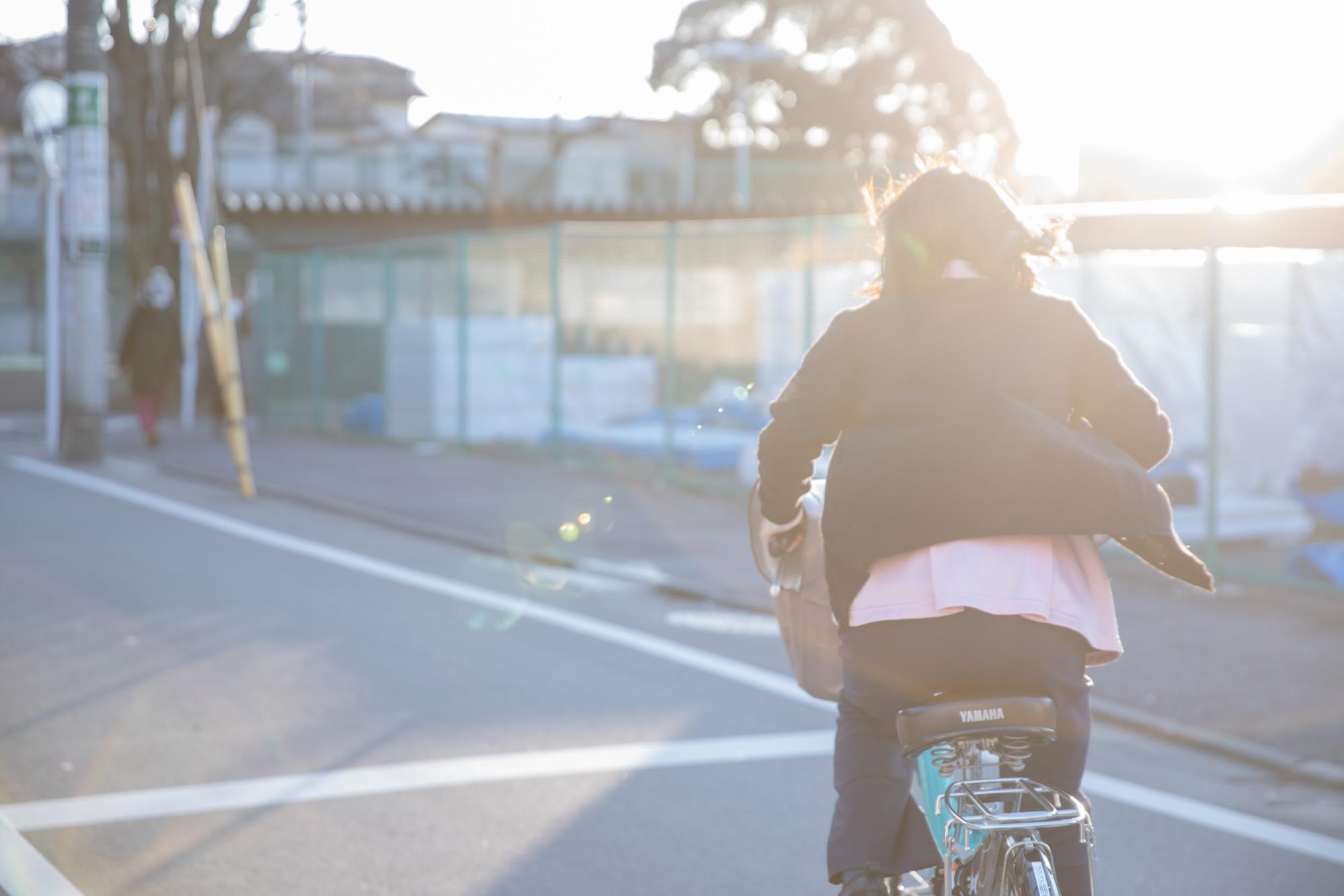 自転車に乗り、患者宅へ向かうスタッフ