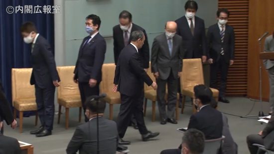 台本を読み終え、会見場から退出する菅首相