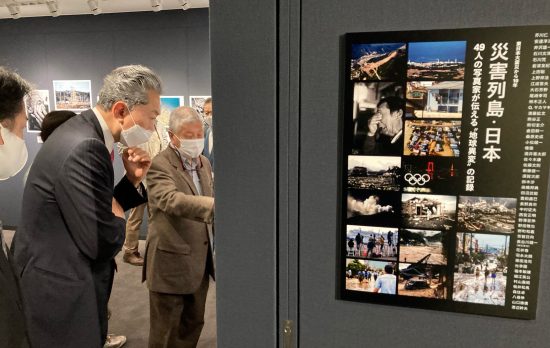 日本各地で起きた災害の写真にじっと見入る鳩山由紀夫・元首相
