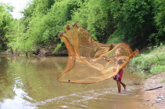 1200px-Katang_youth_casts_fishing_net_in_Laos