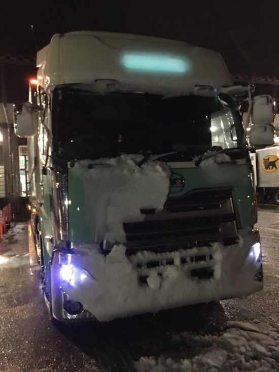 ライトが雪で覆われかけたトラック